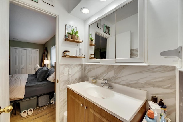 bathroom with vanity, hardwood / wood-style floors, and tile walls