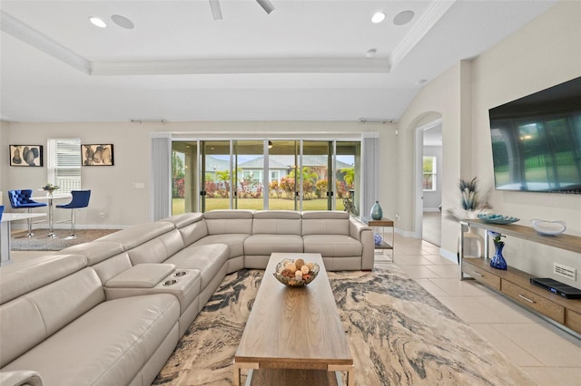 tiled living room featuring a raised ceiling and ornamental molding