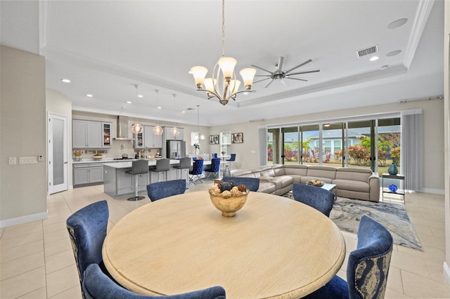 dining area featuring crown molding, light tile patterned floors, a notable chandelier, and a raised ceiling