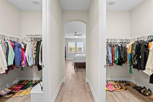 spacious closet with ceiling fan and light hardwood / wood-style flooring