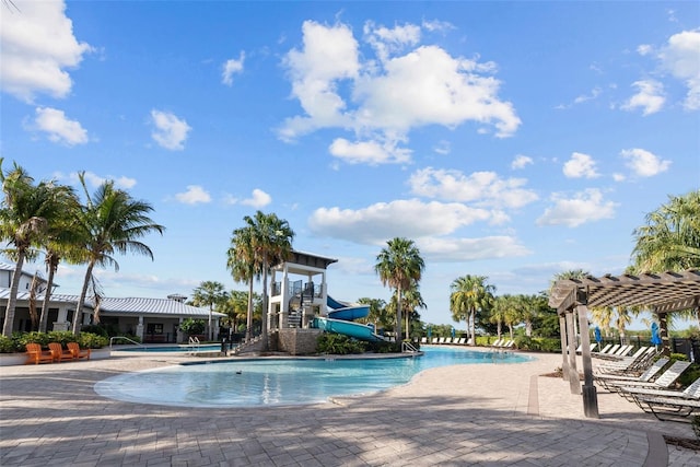 view of swimming pool featuring a patio, a water slide, and a pergola