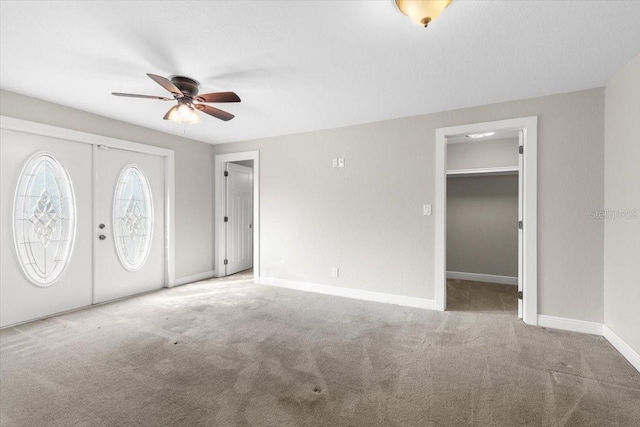 carpeted foyer entrance featuring ceiling fan and french doors