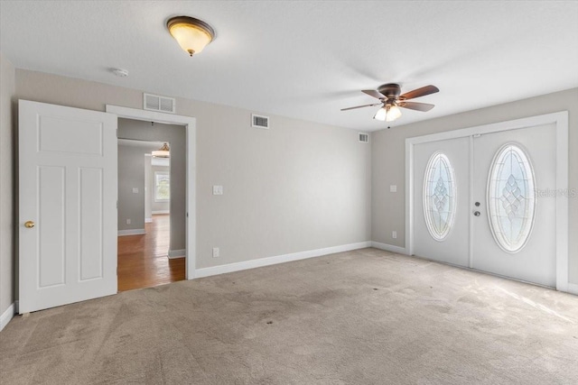 carpeted foyer featuring ceiling fan and french doors