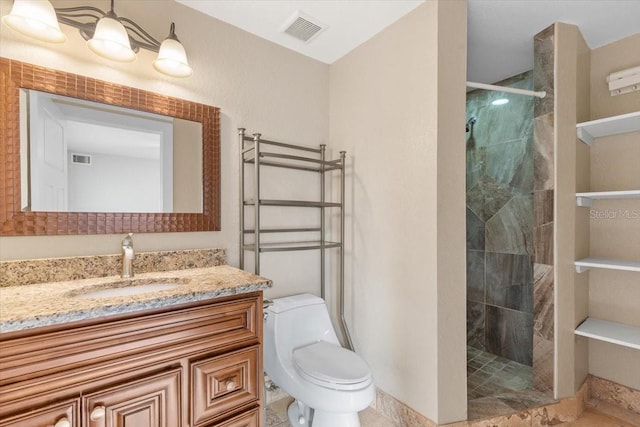 bathroom with toilet, vanity, and a shower with shower door