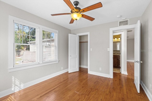 unfurnished bedroom with ceiling fan, a closet, and hardwood / wood-style flooring