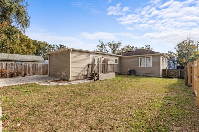 back of property featuring central air condition unit and a lawn