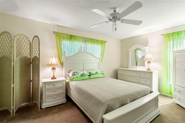 carpeted bedroom featuring a textured ceiling and ceiling fan