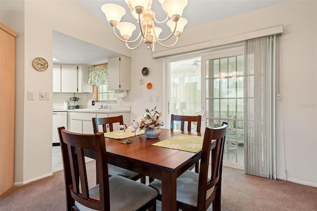 dining area with ceiling fan with notable chandelier, plenty of natural light, sink, and light carpet