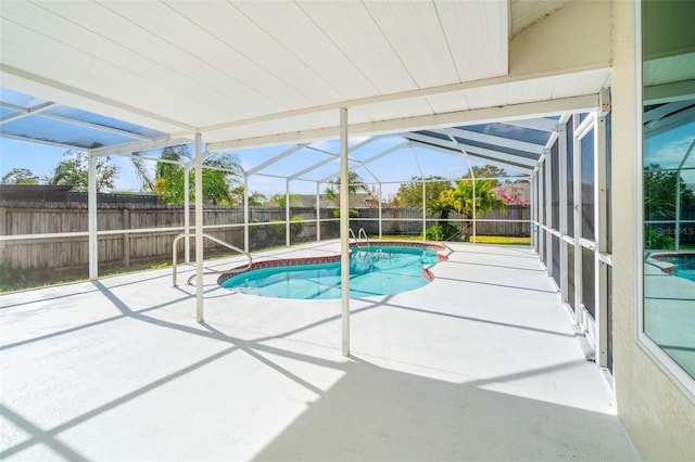 view of pool with glass enclosure and a patio area