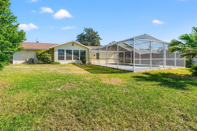 back of property with a lawn and central AC