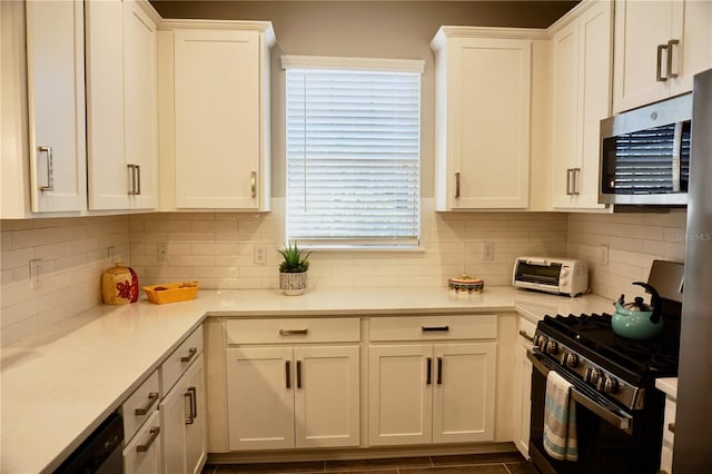 kitchen with stainless steel appliances, light countertops, and white cabinetry