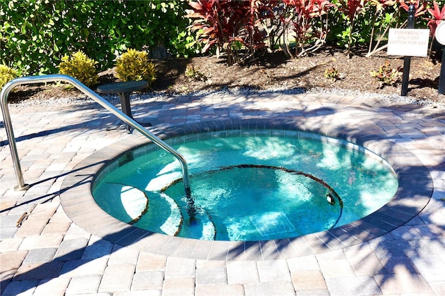 view of swimming pool featuring a hot tub