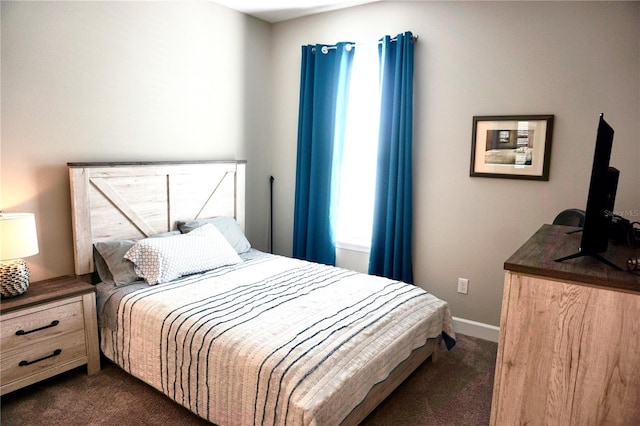 bedroom featuring baseboards and dark colored carpet