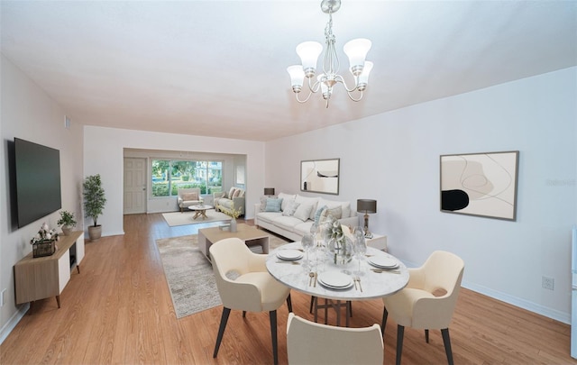 dining room with an inviting chandelier and light hardwood / wood-style flooring