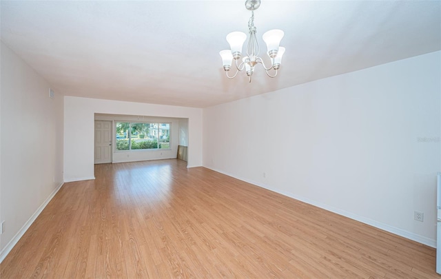 unfurnished living room with a chandelier and light hardwood / wood-style flooring