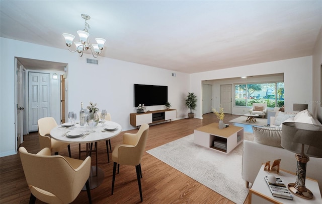 dining room with an inviting chandelier and hardwood / wood-style flooring