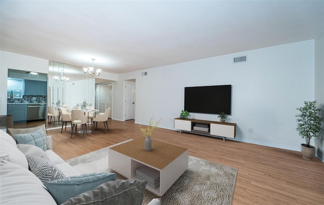 living room with a chandelier and light hardwood / wood-style floors