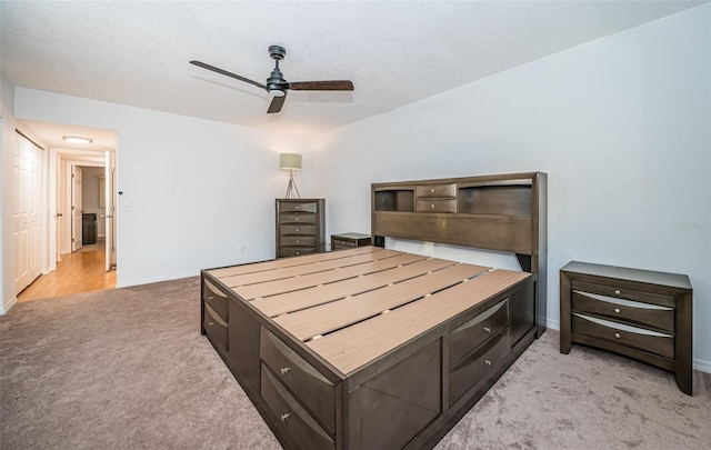 carpeted bedroom featuring a textured ceiling and ceiling fan