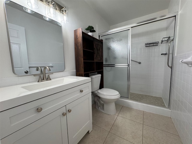 bathroom with vanity, toilet, tile patterned flooring, and a shower with door