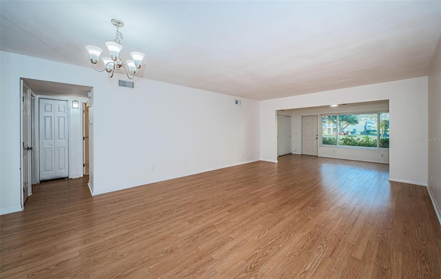 2258 World Parkway Blvd W Unit 8, Clearwater, FL 33763 - empty room featuring light wood finished floors, a chandelier, and baseboards