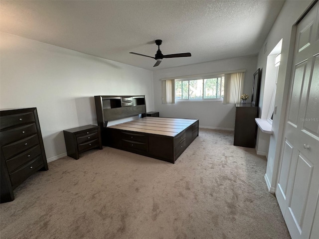2258 World Parkway Blvd W Unit 8, Clearwater, FL 33763 - bedroom with light colored carpet, a textured ceiling, baseboards, and a ceiling fan