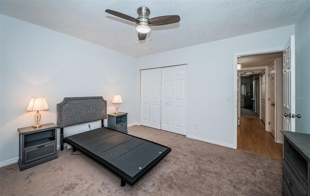 2258 World Parkway Blvd W Unit 8, Clearwater, FL 33763 - carpeted bedroom featuring a closet, baseboards, a ceiling fan, and a textured ceiling