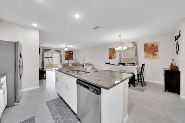 kitchen featuring white cabinetry, a center island with sink, appliances with stainless steel finishes, pendant lighting, and sink