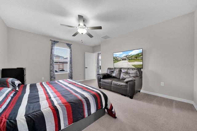 carpeted bedroom featuring a textured ceiling and ceiling fan