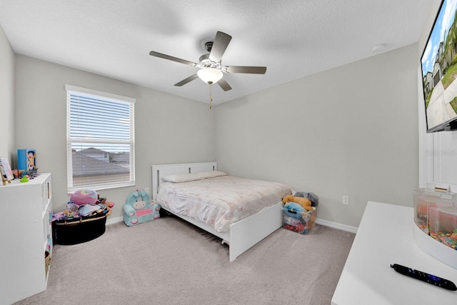 carpeted bedroom featuring ceiling fan and a textured ceiling