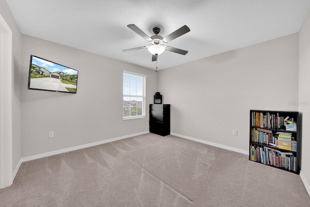 interior space with ceiling fan, a textured ceiling, and light carpet