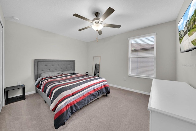 bedroom with ceiling fan and light colored carpet