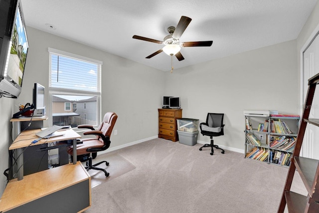 carpeted home office featuring ceiling fan