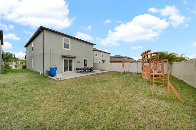 back of house featuring a lawn, central AC unit, a patio, and a playground