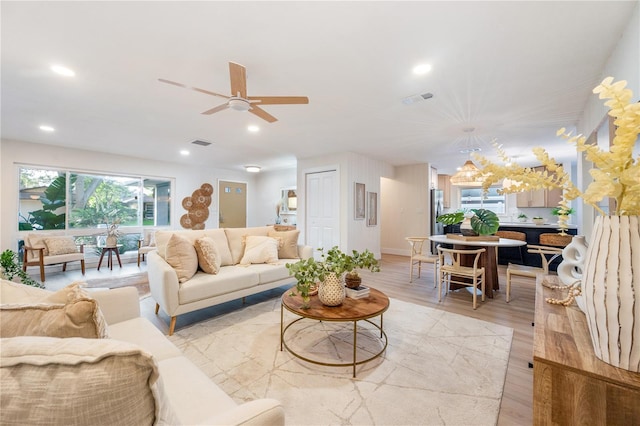 living room featuring ceiling fan and light hardwood / wood-style floors