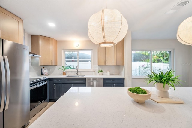 kitchen featuring light brown cabinetry, sink, backsplash, and appliances with stainless steel finishes