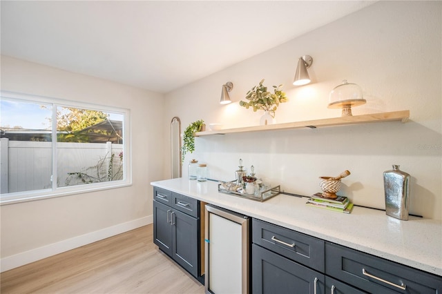 kitchen featuring gray cabinets, fridge, and light hardwood / wood-style flooring