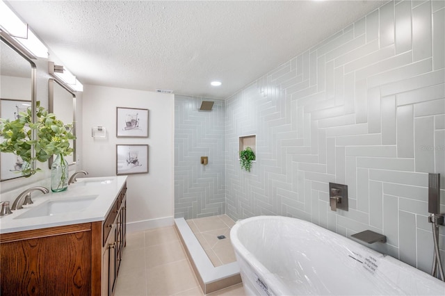 bathroom featuring vanity, tile patterned floors, a textured ceiling, and a tile shower