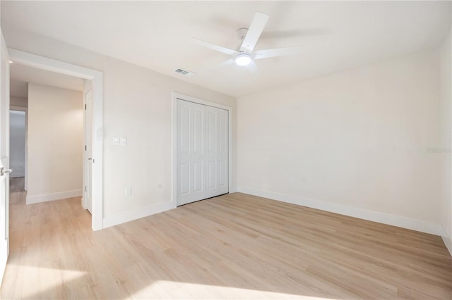 unfurnished bedroom with ceiling fan, a closet, and light hardwood / wood-style flooring