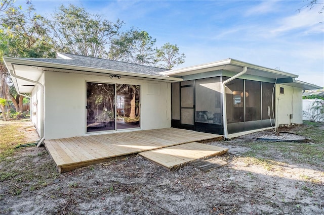 rear view of house with a wooden deck and a sunroom