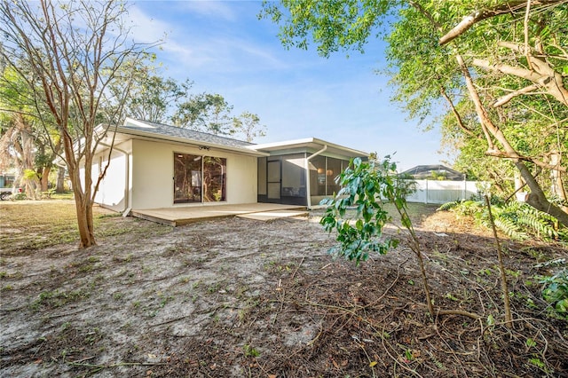 rear view of house featuring a sunroom and a patio