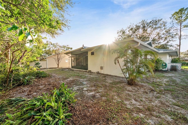 back of property with a sunroom and central air condition unit