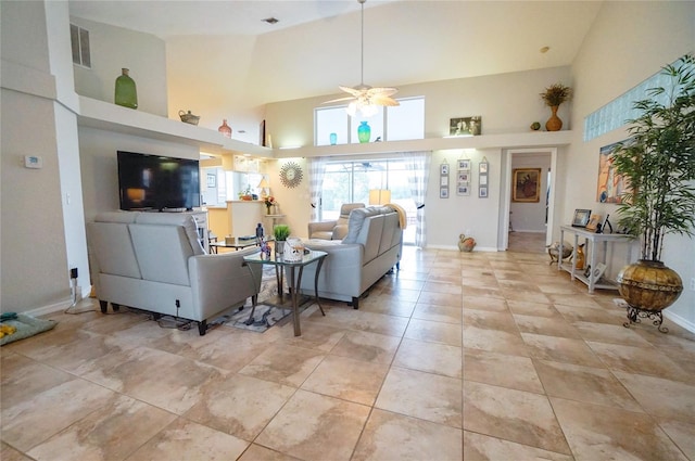 living room featuring ceiling fan and a high ceiling