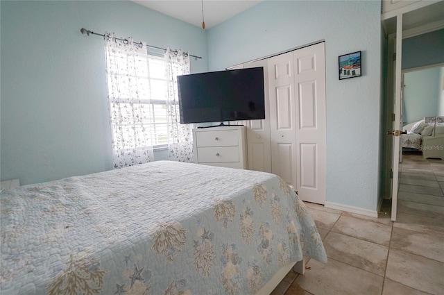 tiled bedroom with a closet