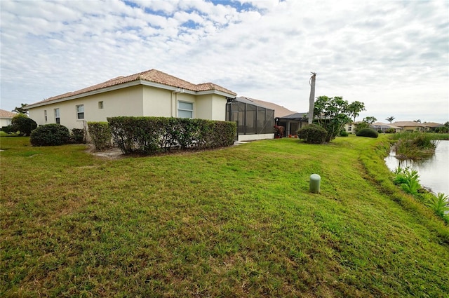 view of side of property with a lanai and a yard