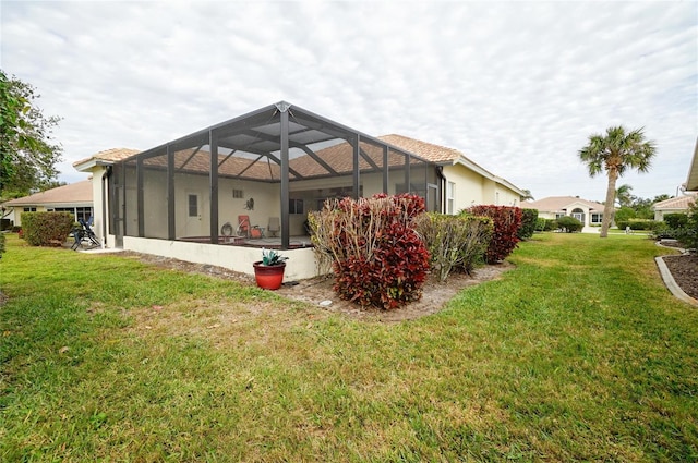 back of property with a lanai and a lawn