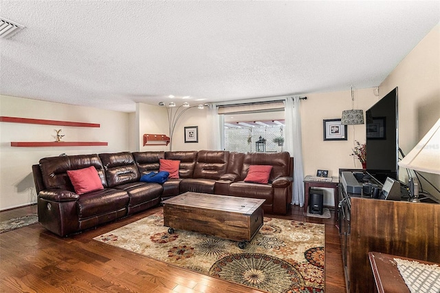 living room featuring dark wood-type flooring and a textured ceiling