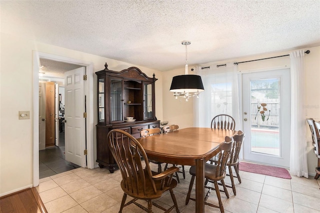 tiled dining room with a textured ceiling