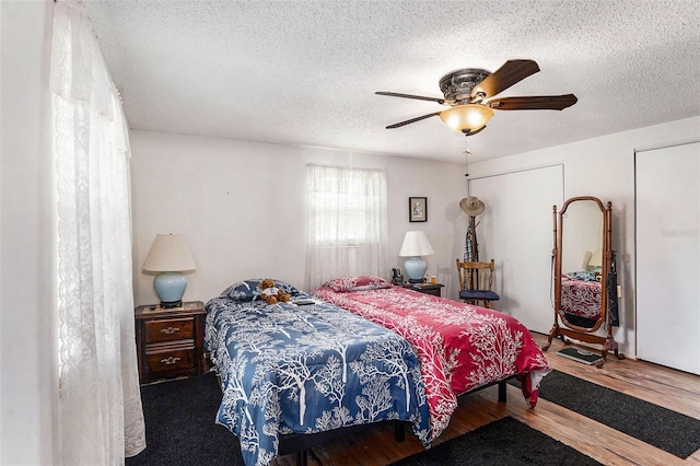 bedroom with hardwood / wood-style floors, a textured ceiling, and ceiling fan