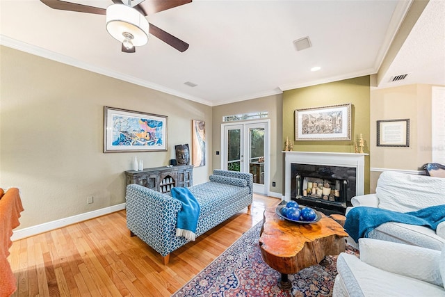 living room with french doors, crown molding, and hardwood / wood-style flooring