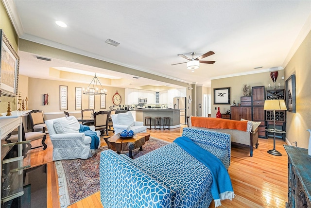 living room featuring ornamental molding, ceiling fan with notable chandelier, and hardwood / wood-style floors